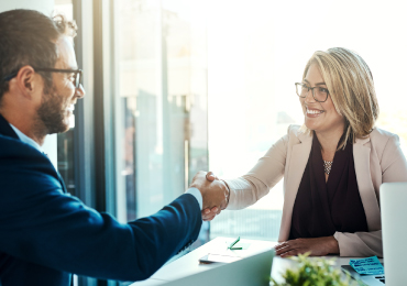 man and woman shaking hands in office setting