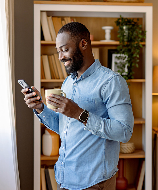 Person using phone drinking coffee.