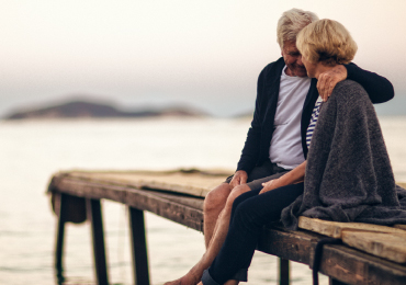 Mature couple sitting on lake dock