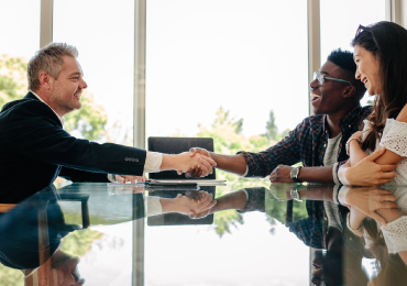 Man shaking hands with young couple